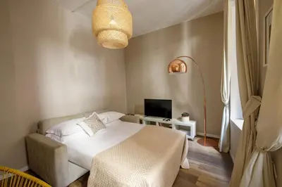 a bedroom with a white bed and a television at The right place 4U Grotte Apartment in Rome