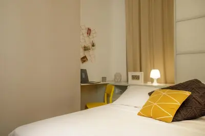 a bedroom with a bed with a yellow pillow on it at The right place 4U Grotte Apartment in Rome