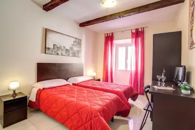 a bedroom with a red bed and a television at Hotel Mosaic in Rome