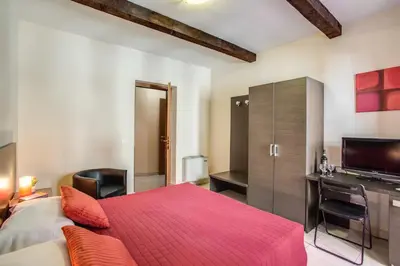 a bedroom with a red bed and a television at Hotel Mosaic in Rome