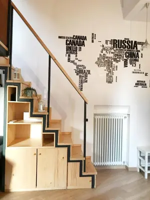 a staircase in a living room with a wall mural of cities at Terrace99 in Rome
