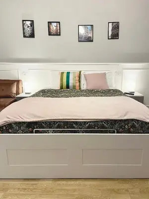 a bedroom with a white bed with three pictures on the wall at Monti49 GuestHouse in Rome