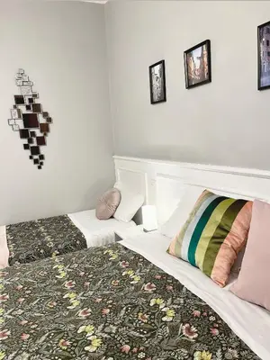 a bedroom with two beds and pictures on the wall at Monti49 GuestHouse in Rome