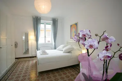 a bedroom with a white bed and purple flowers at Morin 27 in Rome