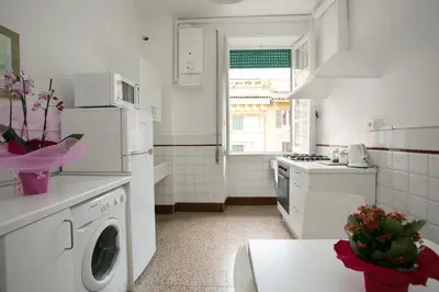 a white kitchen with a washing machine and a stove at Morin 27 in Rome