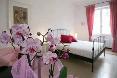 a bedroom with a bed and a vase with purple flowers at Morin 27 in Rome