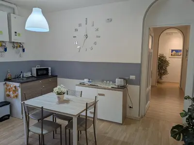 a kitchen with a table and chairs and a clock on the wall at El Dorado Vatican in Rome