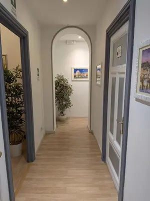a hallway with an archway and potted plants in a building at El Dorado Vatican in Rome