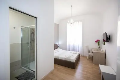 a bedroom with a bed and a glass shower at El Dorado Vatican in Rome