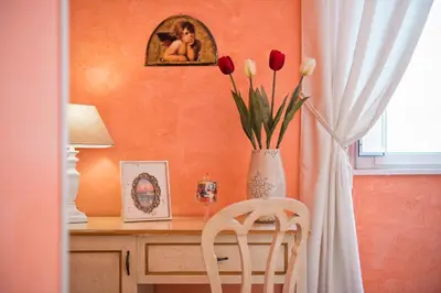 a desk with a vase of flowers and a vase of tulips at Navona Tower Relais in Rome