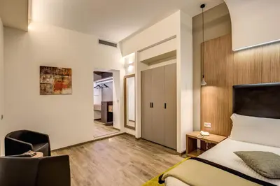 a bedroom with a bed and a chair in a room at Trevi Collection Hotel - Gruppo Trevi Hotels in Rome