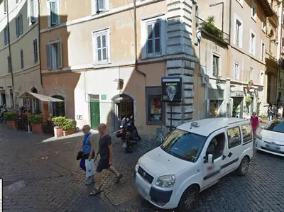 a group of people standing next to a car on a street at Navona First Rooms in Rome