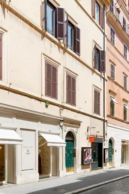 a building with umbrellas on the side of a street at HT Romeo Al Babuino in Rome