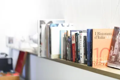 a row of books sitting on a shelf at HT Romeo Al Babuino in Rome