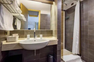 a bathroom with a sink and a shower at HT Romeo Al Babuino in Rome