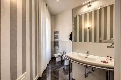a bathroom with a sink and a toilet at La Foresteria Luxury Suites in Rome