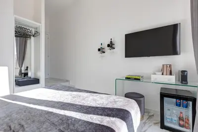 a white bedroom with a bed and a window at St. Peter Grand Suite in Rome