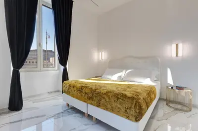 a white bedroom with a bed with a large window at St. Peter Grand Suite in Rome
