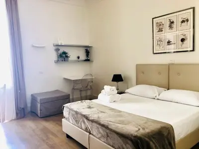 a bedroom with a large bed and a table at Bea Suites Luxury Rooms in Rome