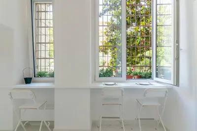 a white room with three windows and chairs at Bea Suites Luxury Rooms in Rome