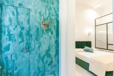 a room with a bed and a blue wall at Bea Suites Luxury Rooms in Rome