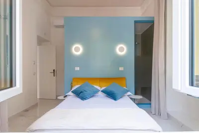 a bed with blue walls and two blue pillows at Bea Suites Luxury Rooms in Rome