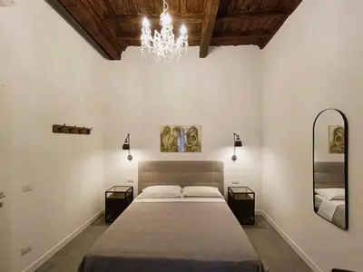 a bedroom with a large bed and a chandelier at La tua casa a Piazza del Popolo in Rome