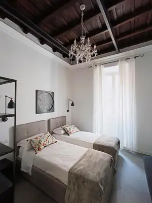 a bedroom with two beds and a chandelier at La tua casa a Piazza del Popolo in Rome