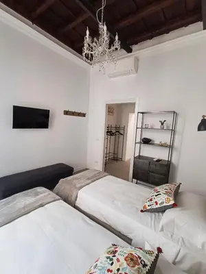 a bedroom with two beds and a chandelier at La tua casa a Piazza del Popolo in Rome