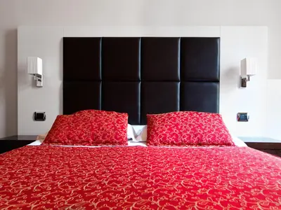 a red bed with a black headboard and two red pillows at Cenci Bed & Breakfast Fontana di Trevi in Rome
