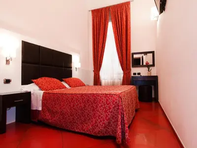 a bedroom with a red bed and a window at Cenci Bed & Breakfast Fontana di Trevi in Rome