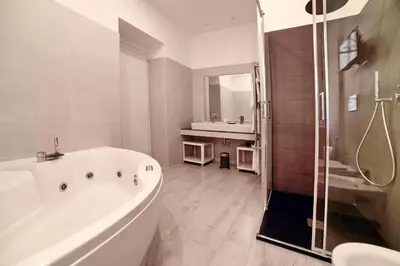 a white bathroom with a tub and a shower at Coladir Guest House in Rome