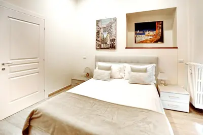 a white bedroom with a large white bed in it at Coladir Guest House in Rome