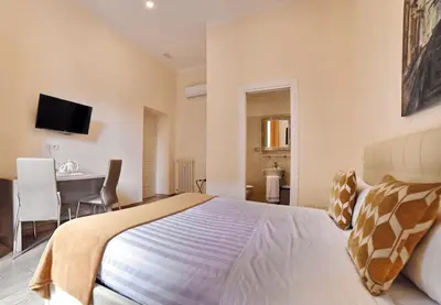 a bedroom with a bed and a desk and a table at Coladir Guest House in Rome