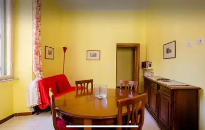 a dining room with a table and chairs and a couch at Casa vacanze 