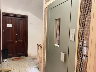 a hallway with a door and a window and a floor at Roman Holidays Rooms Otranto in Rome