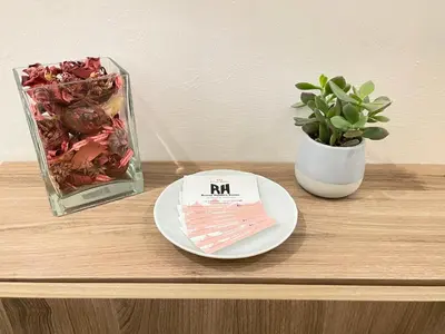 a table with a plate and a vase with a plant at Roman Holidays Rooms Otranto in Rome