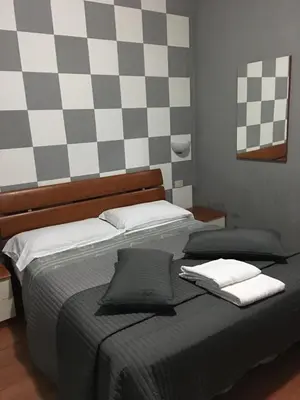 a bed with two pillows and a checkered wall at Hi Termini in Rome