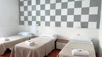 a bedroom with a bed with a checkered wall at Hi Termini in Rome