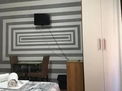 a room with a tv on a striped wall at Hi Termini in Rome