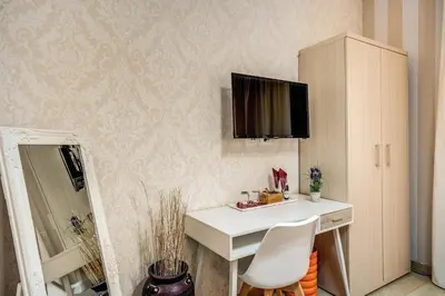 a room with a desk and a tv on a wall at Marta Inn in Rome