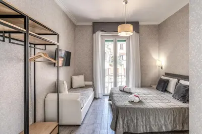a bedroom with a bed and a couch and a window at Marta Inn in Rome