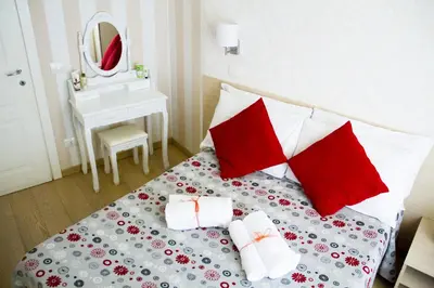 a bedroom with a bed with red and white pillows at Marta Inn in Rome