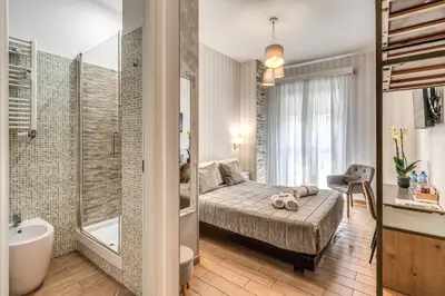 a bedroom with a bed and a bathroom with a tub at Marta Inn in Rome