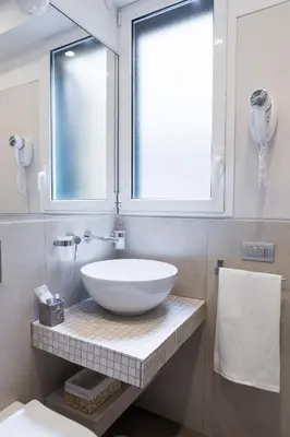 a bathroom with a bowl sink and a window at Rhome Suites in Rome