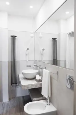 a white bathroom with a sink and a toilet at Rhome Suites in Rome