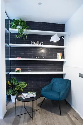 a living room with a blue chair and a table at Rhome Suites in Rome
