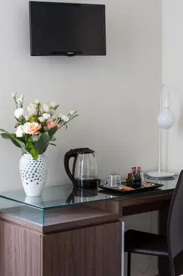 a desk with a vase with flowers on it at Rhome Suites in Rome