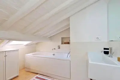 a white bathroom with a sink and a tub at Pantheon Charming Attic | Romeloft in Rome