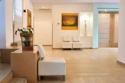 a living room with a chair and a table at Occidental Aurelia in Rome